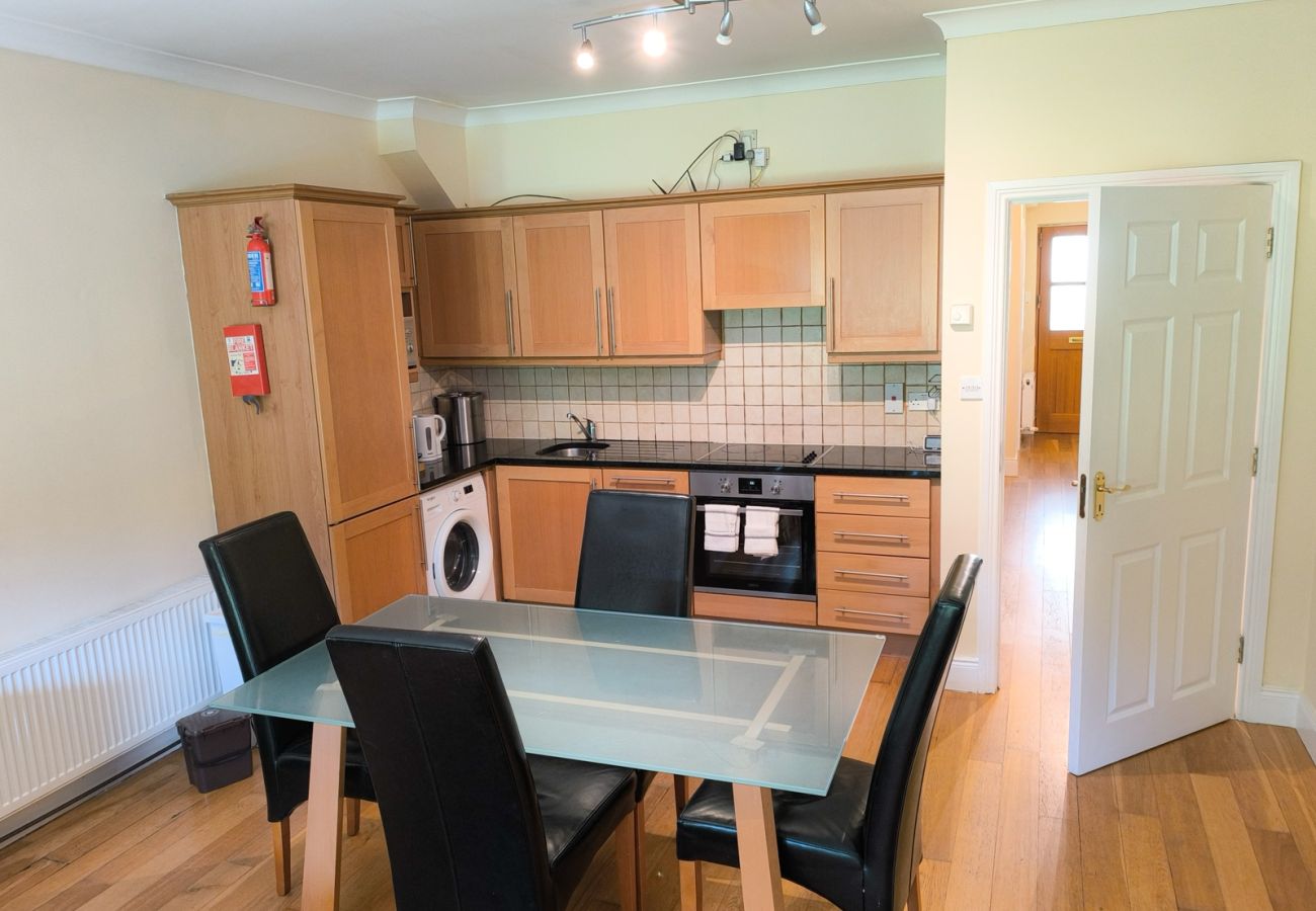 Heyward Mews Holiday Homes, Modern bright kitchen, wooden flooring. Dining table seating for four. 