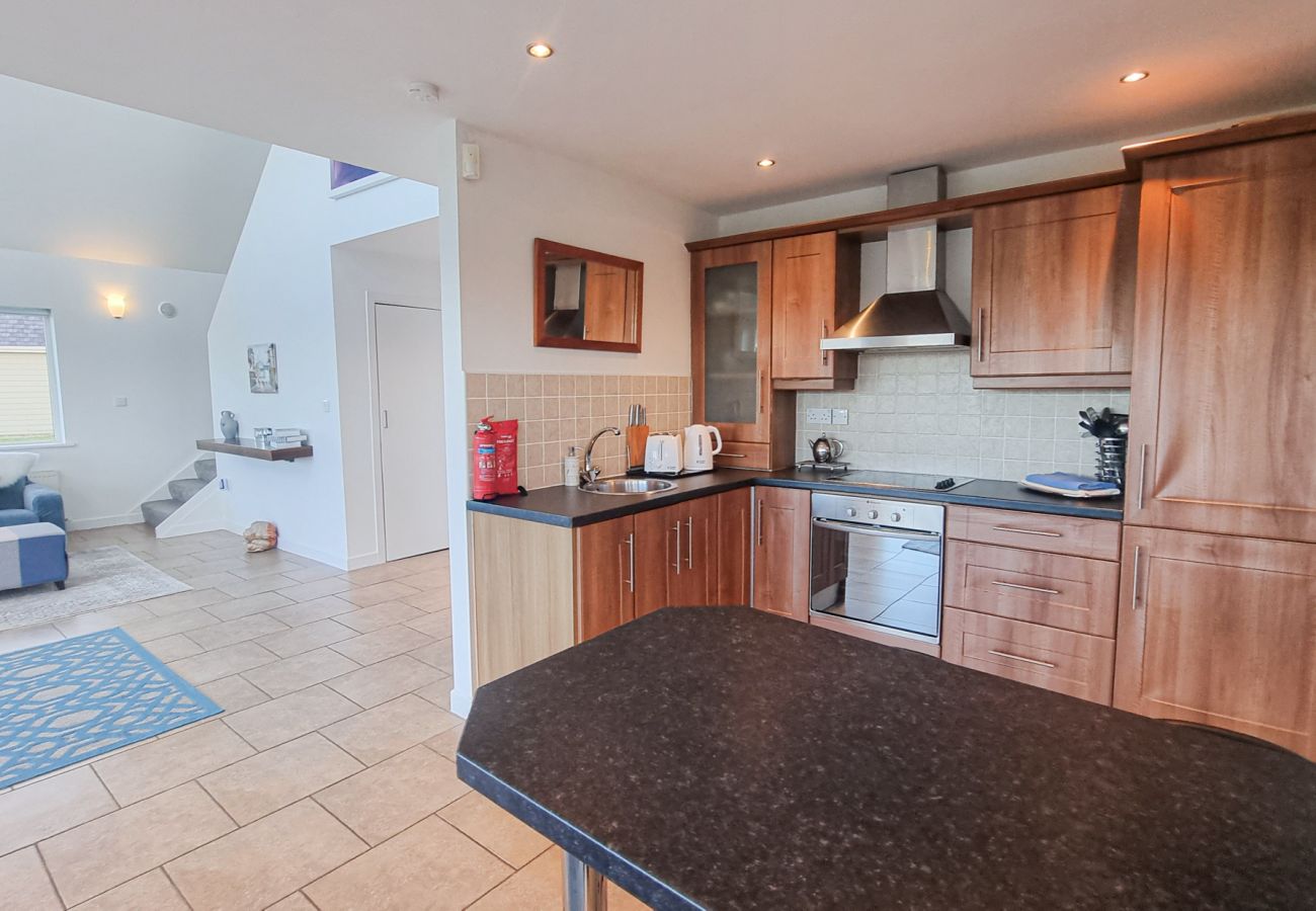 Riverrun Holiday Home No 15. Bright living room and open plan kitchen with counter.