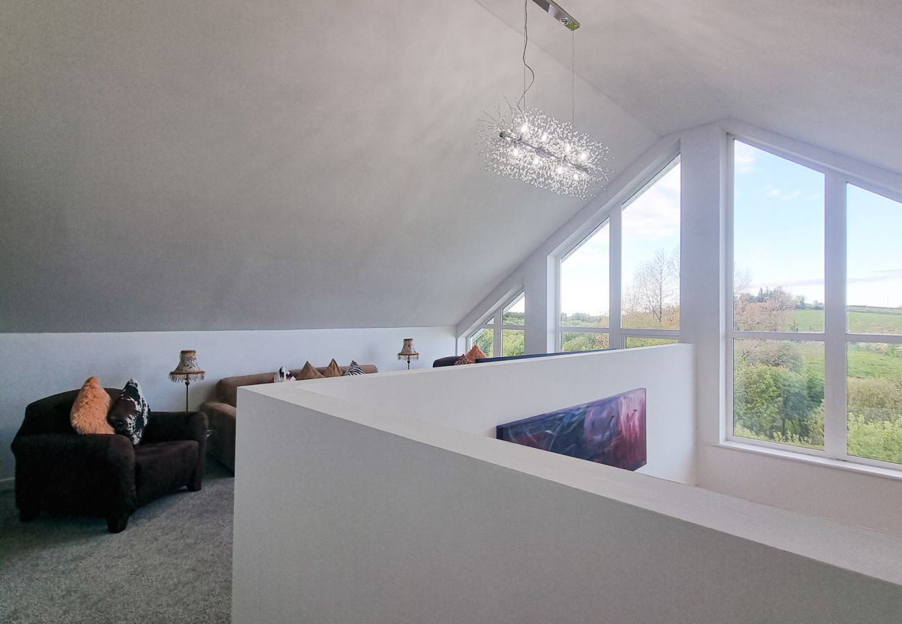Riverrun Holiday Home No 15.  Mezzanine area with large windows a view to garden. 
