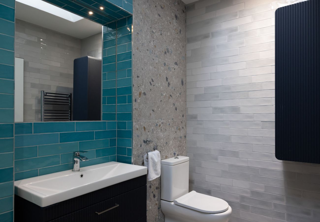 Harbourview Penthouse Apartment, Kincora. Bath with shower combined. Toilet. Large sink. Modern tiling,.