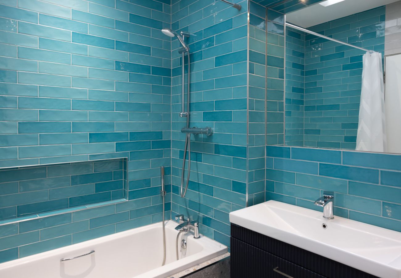 Harbourview Penthouse Apartment, Kincora. Bath with shower combined. Large sink. Turquoise tiling. Clean, spacious modern. 