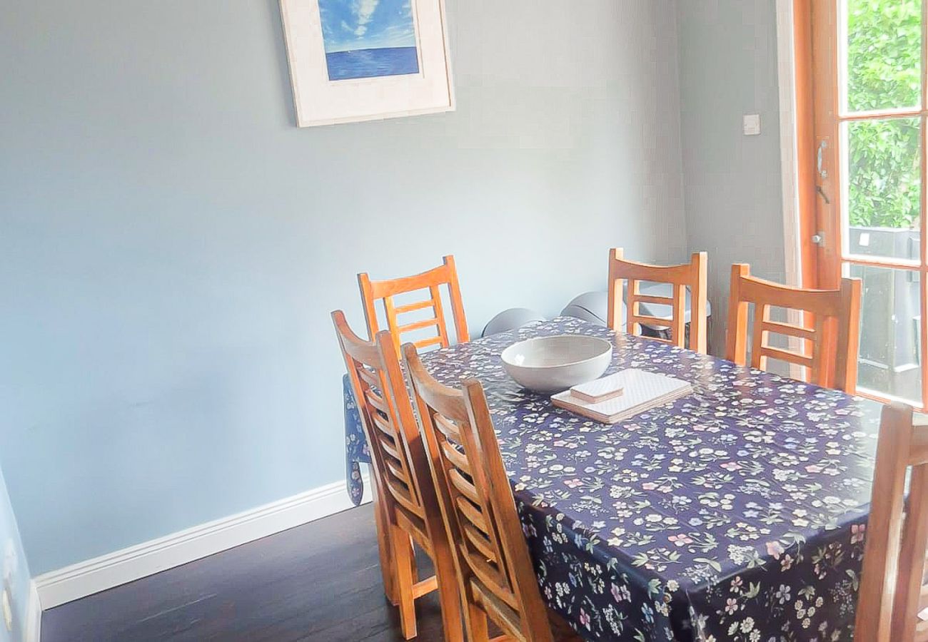 Dingle Town Holiday Home. Dining table seating six with large window and a vew of garden. 