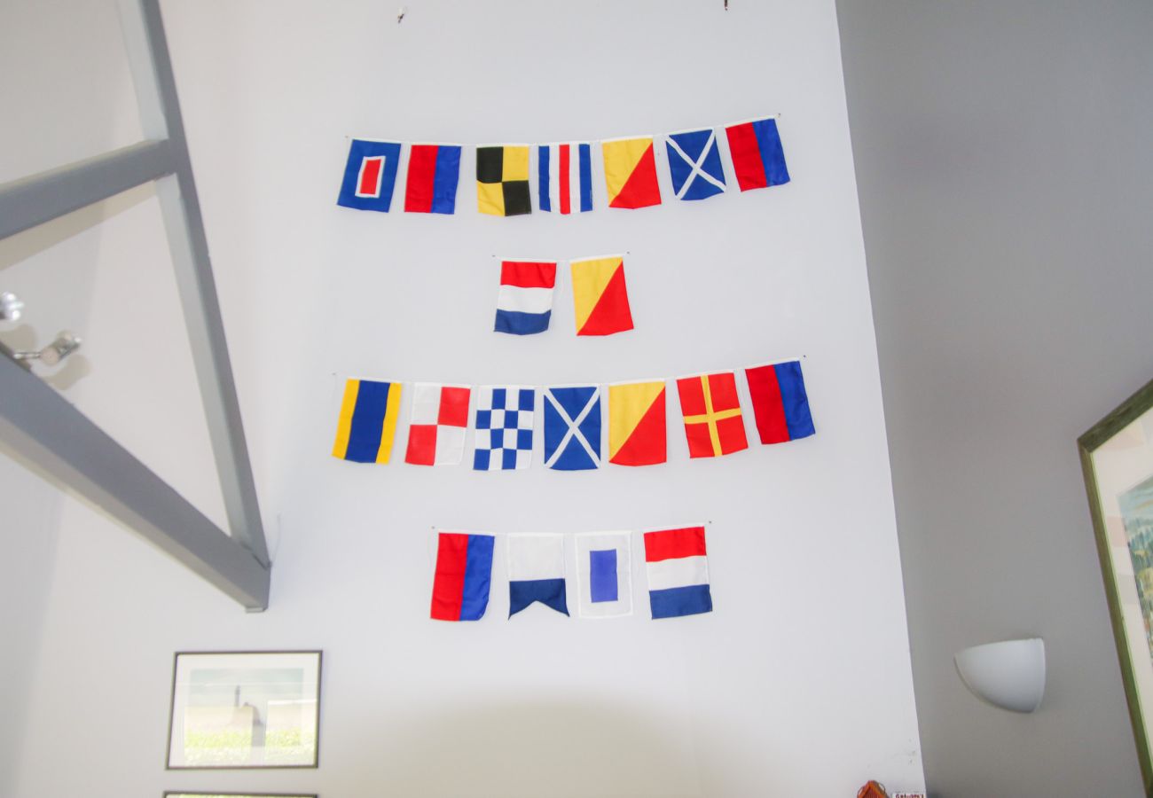 Decorative wall with international flags in Dunmore Villas Holiday Home No 1 - holiday home. Contemporary interior with stove, wooden floors, soft fur