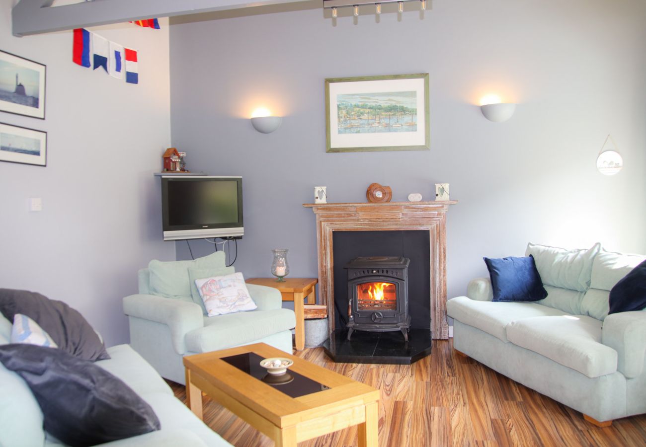 Lounge area in Dunmore Villas Holiday Home No 1 - holiday home.  Contemporary interior with stove, wooden floors, soft furnishing.