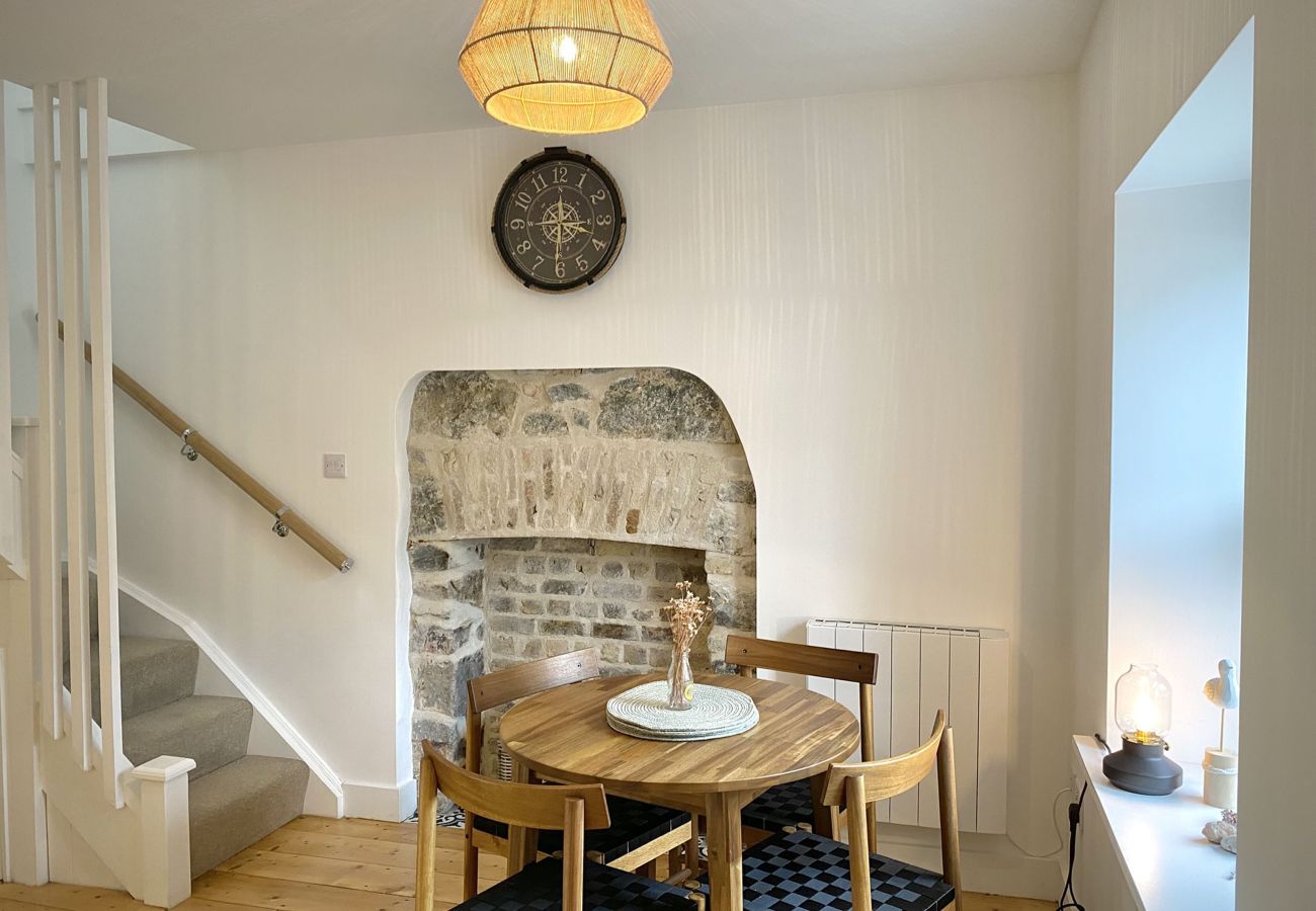Clifden Town Townhouse. Connemara. Dining table seats 4. View to street. Open fire brick effect. Stairwell.
