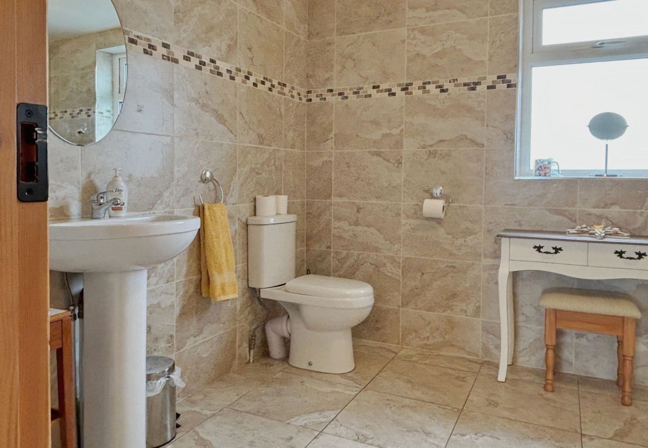 Conroy's Cottage Carna. Modern bathroom with WC and sink. and dressing table. Stylish tiles.