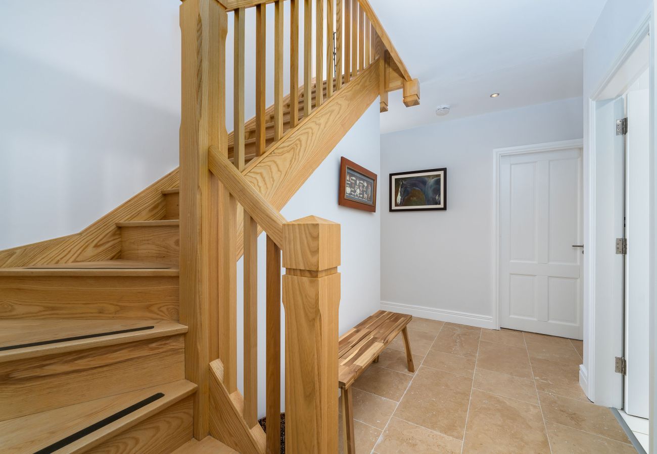 Ocean View Holiday Home. Bright spacious tiled hall with wooden staircase. 