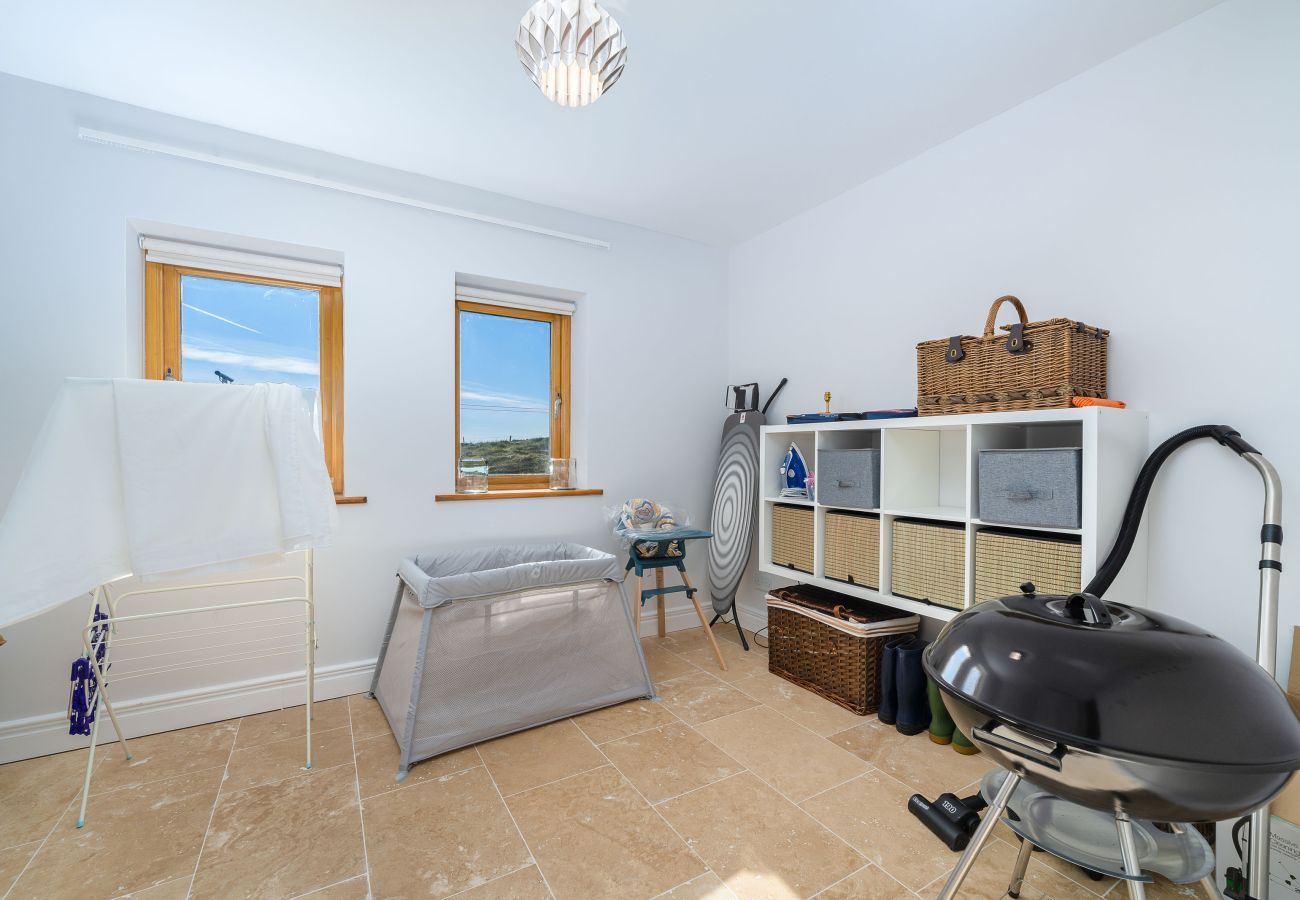 Ocean View Holiday Home. Utility room with washing machine and outdoor furniture. 