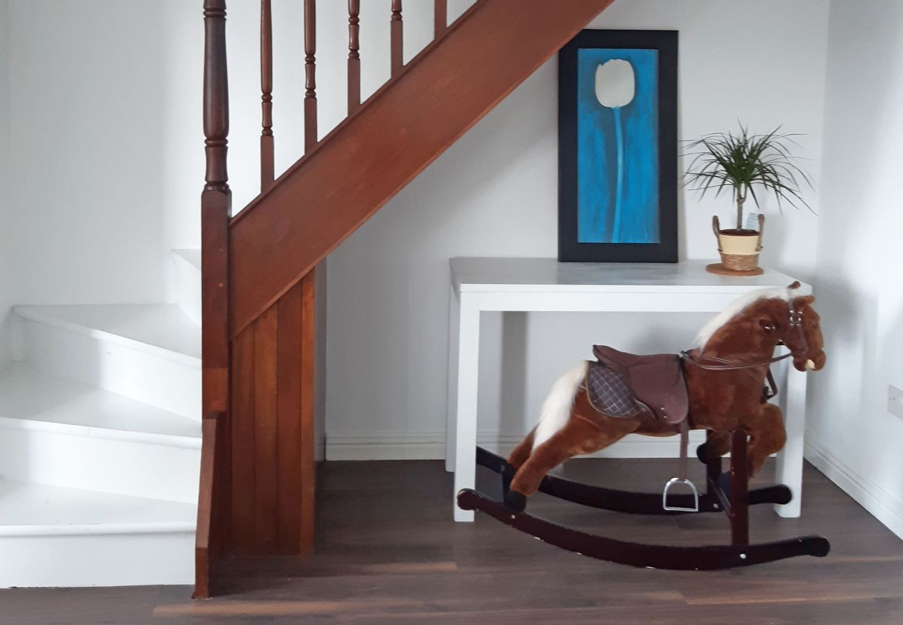 Glynsk Holiday Home. Hall and stairs. Hall table and rocking horse. 