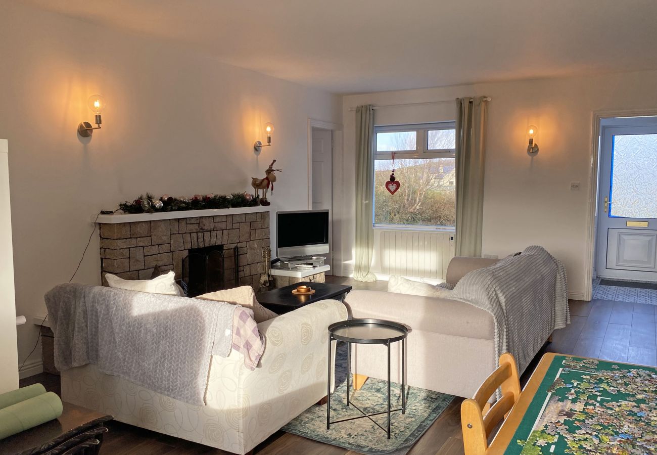 Glynsk Holiday Home. Cosy living room with two sofas and open fire.