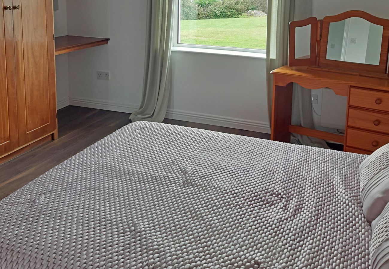 Glynsk Holiday Home. Double bed, storage view to garden.  