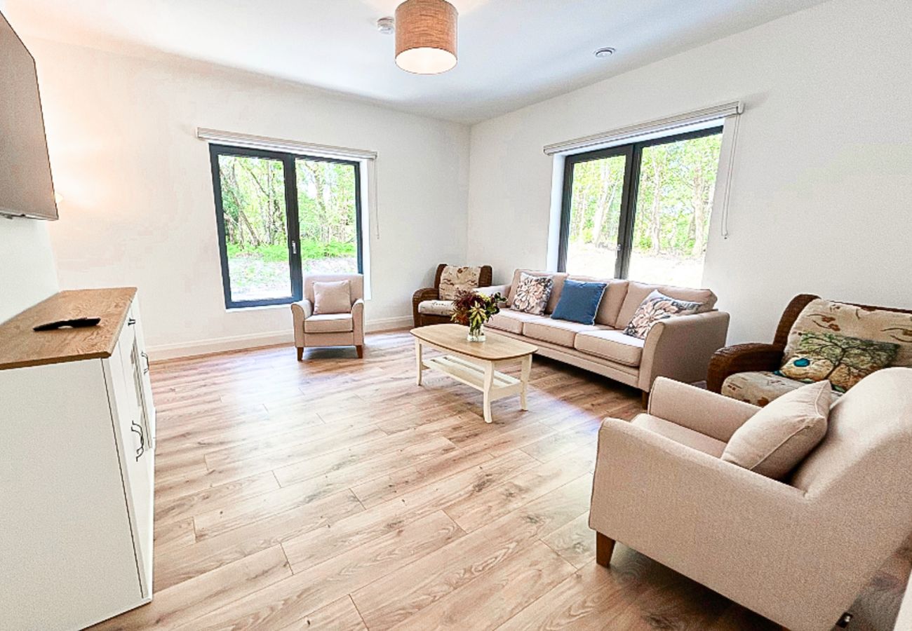 Lough Conn Haven Holiday Home. Open plan spacious bright lounge. Wooden floor, large windows, comfortable furniture. 