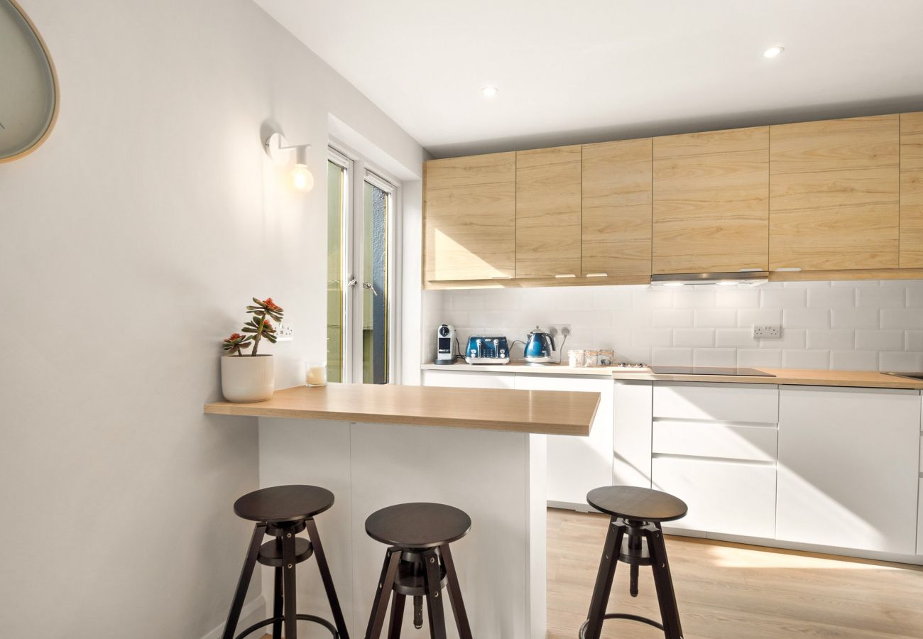 The Town Place Apartment Clifden. Modern Kitchen, bar stools and counter, bright modern dining. 