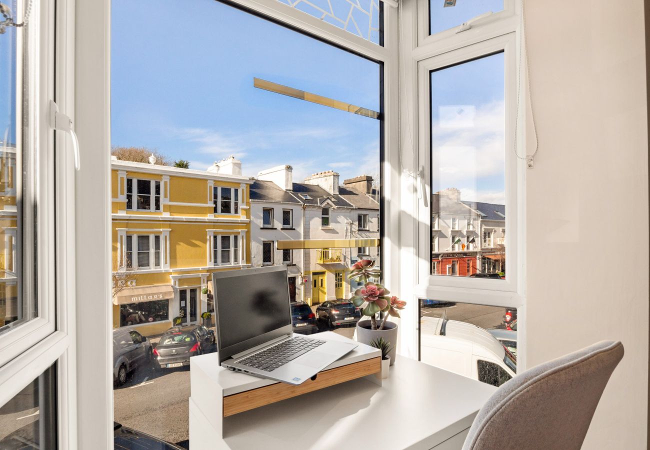 Clifden Boutique Apartment. View to street, seating and desk in bay window. 