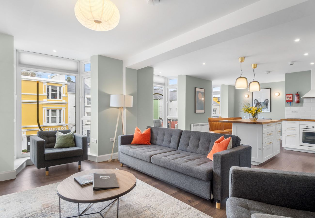 Clifden Boutique Apartment. Modern Living room. Open plan kitchen diner, view to street. Bright tasteful furniture. 
