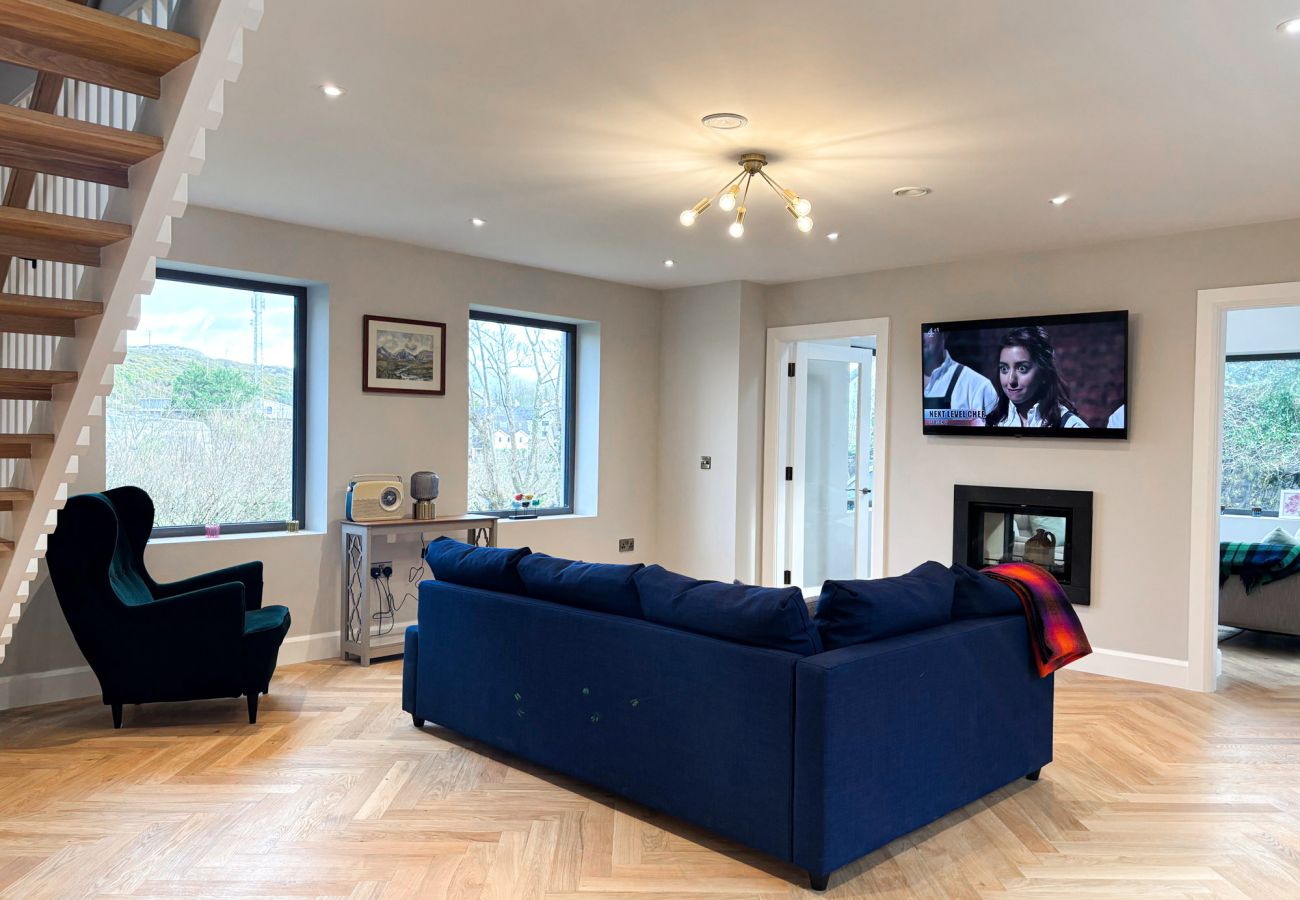 Clifden Holiday Home. Modern luxury home. Sofa couch with TV, stairs open plan. 