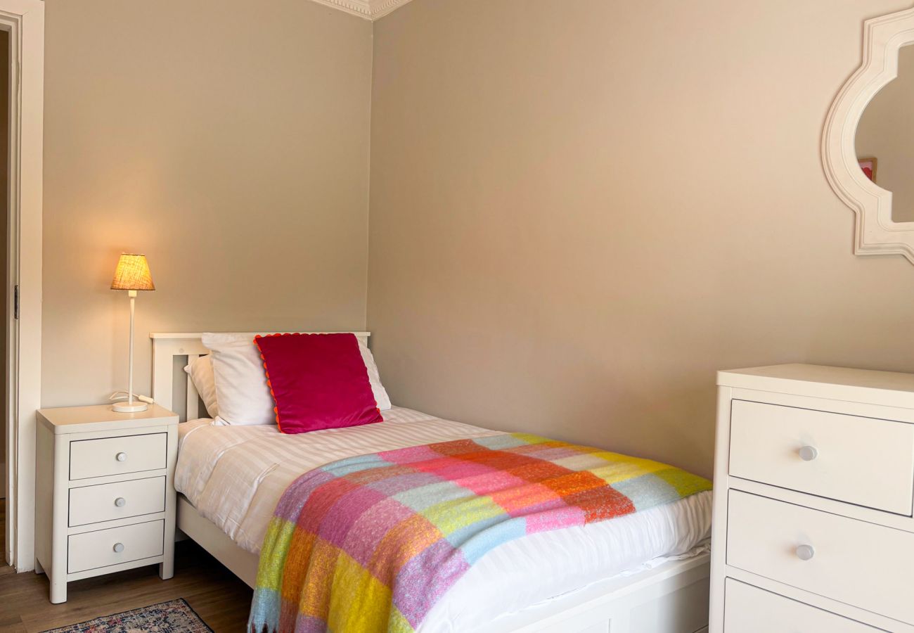 Luxurious Clifden Cottage. Colourful bright bedroom with single bed. 