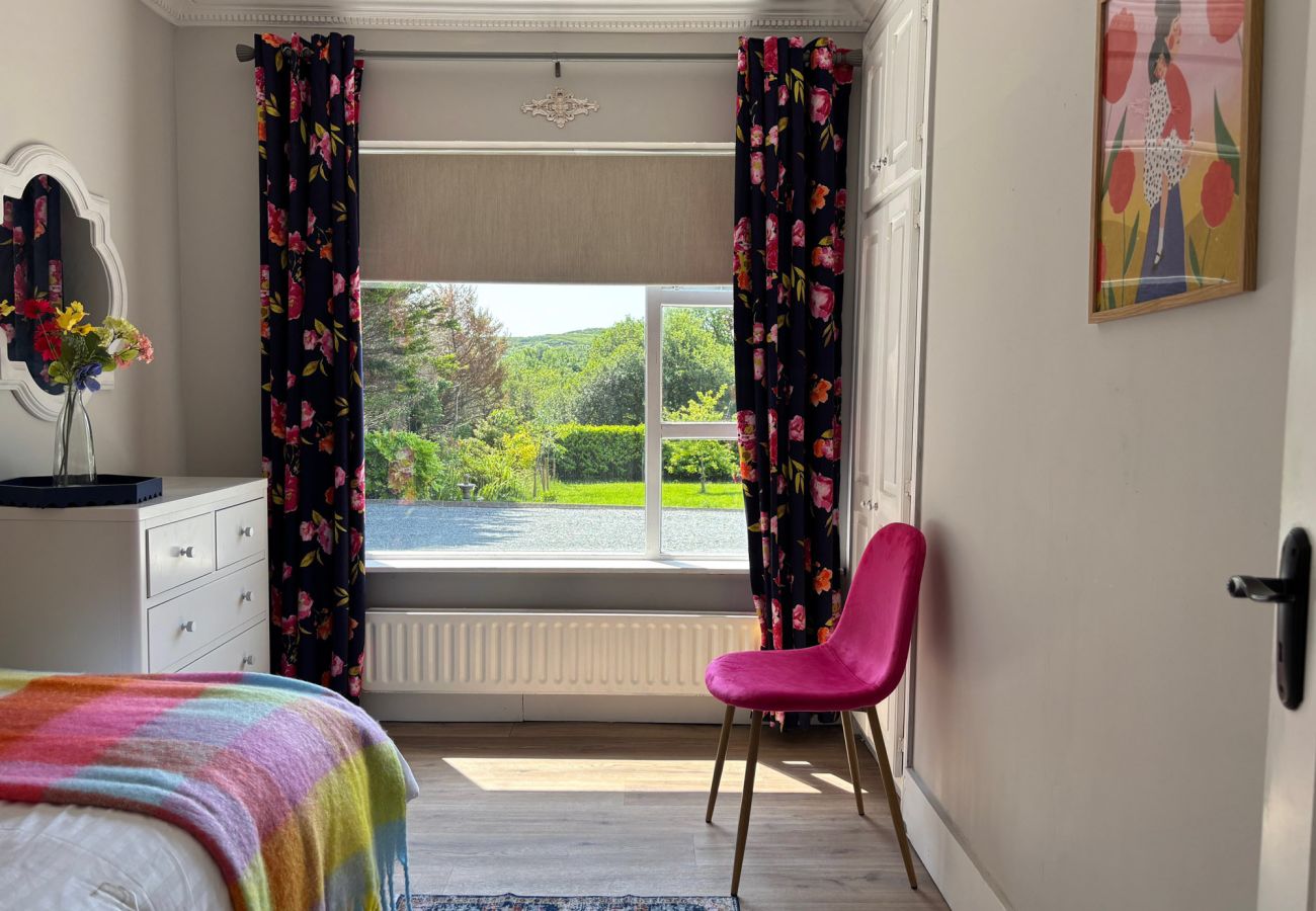 Luxurious Clifden Cottage. Colourful bright bedroom with single bed. Views to garden