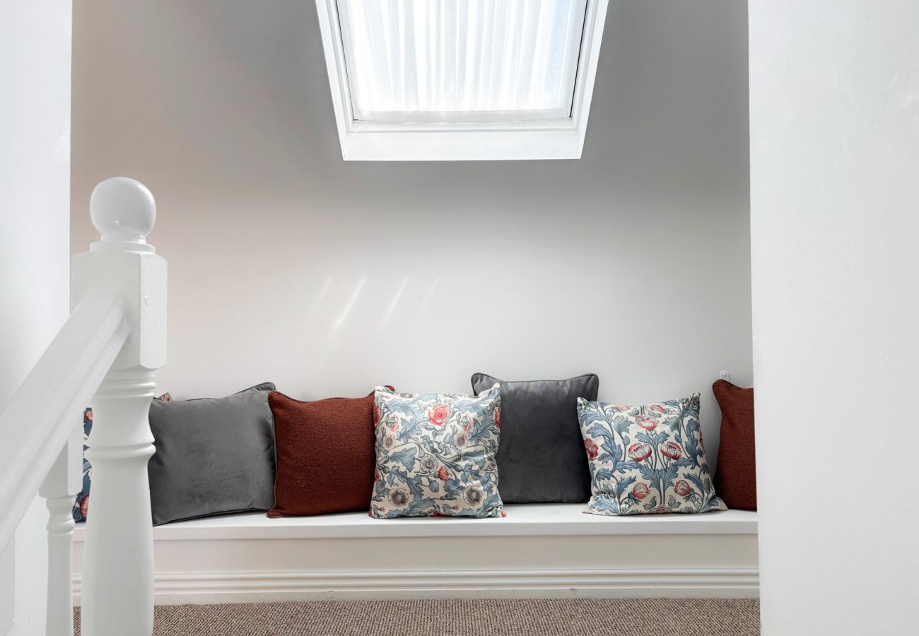 Luxurious Clifden Cottage. open staircase to upper floor with window and seated area