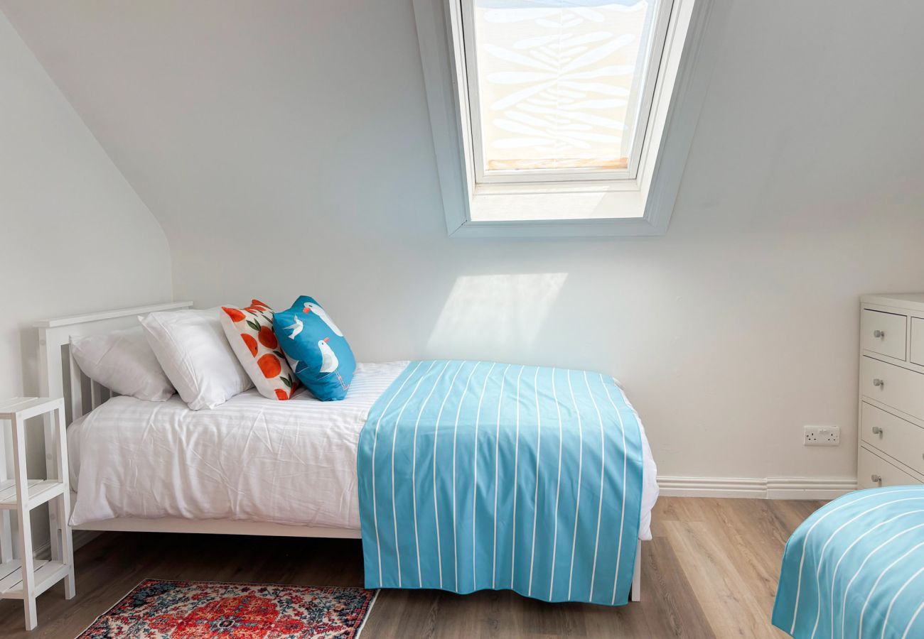 Luxurious Clifden Cottage. Twin room with bright colours and wooden floor. Attic. 