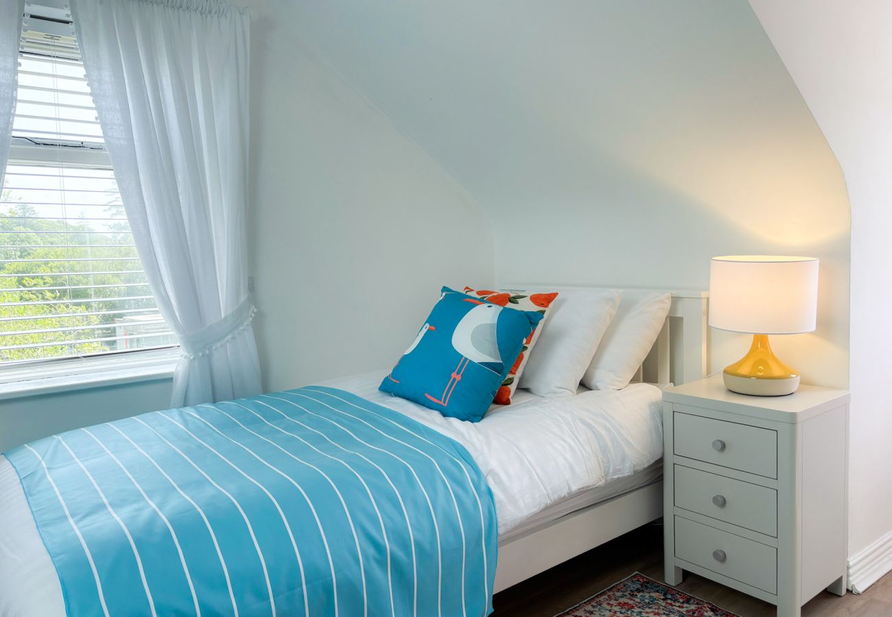 Luxurious Clifden Cottage. Twin room with bright colours and wooden floor. Attic. 