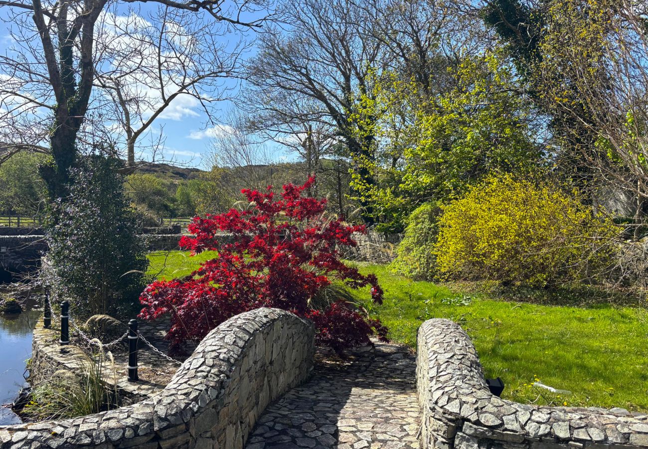 Luxurious Clifden Holiday Home. Garden stone walls on bridge over river. 