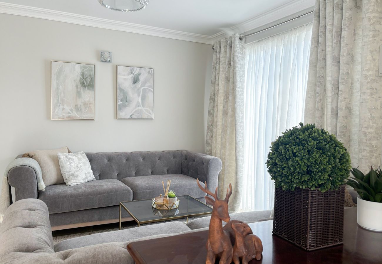 Luxurious Clifden Holiday Home. Two comfortable fabric couches at large window.